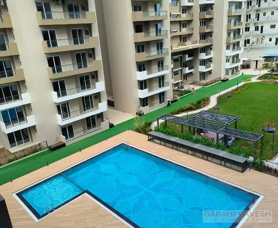 swimming pool at Uptown Skylla surrounded by lounge chairs and palm trees" "State-of-the-art gymnasium with premium equipment in Uptown Skylla Zirakpur