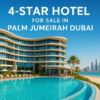 “Luxury 4-star hotel for sale in Palm Jumeirah Dubai with modern architecture, rooftop pool, Arabian Gulf views, and bright premium beachfront setting.”